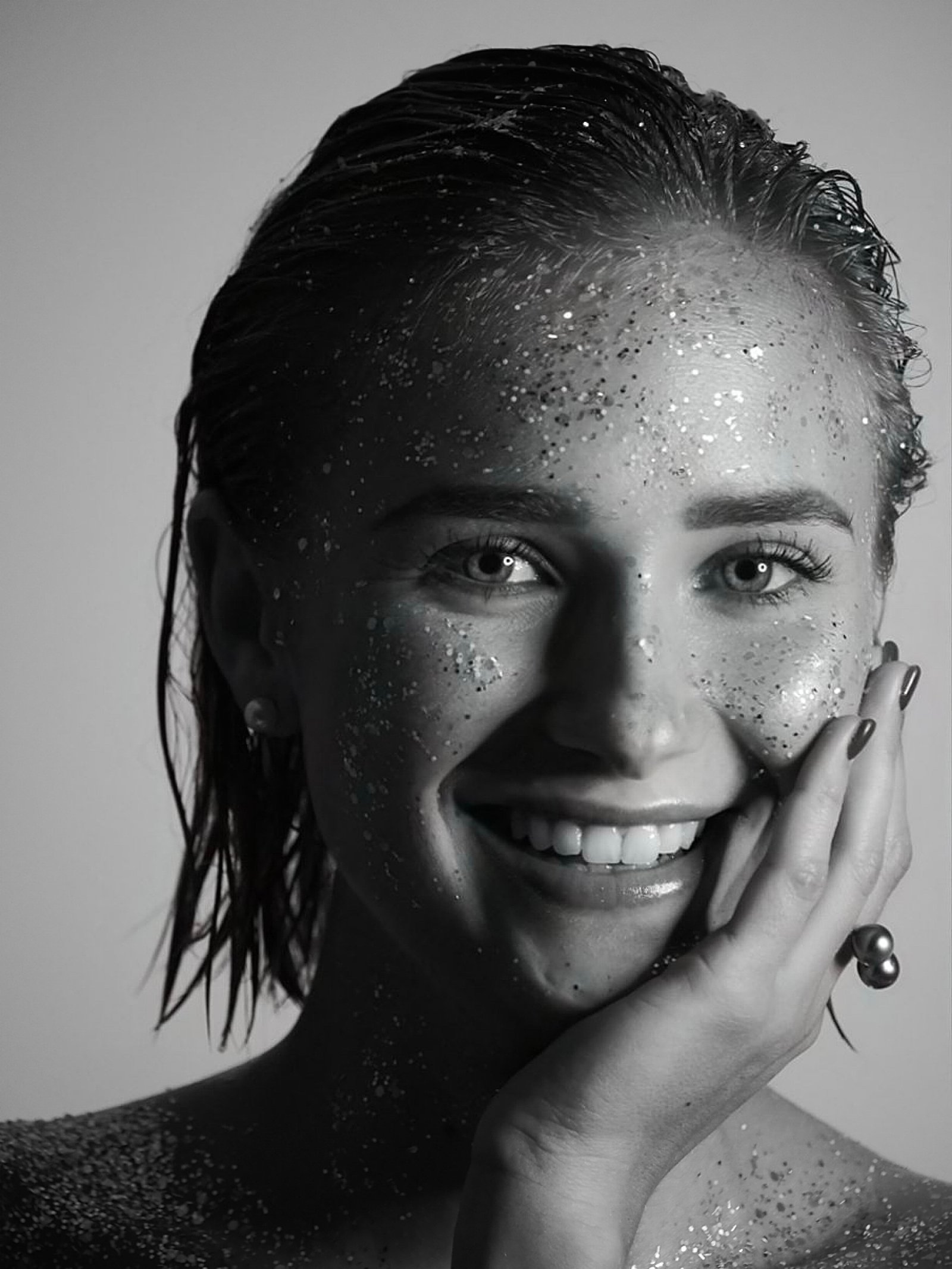 une jeune femme souriant avec des paillette sur le visage 