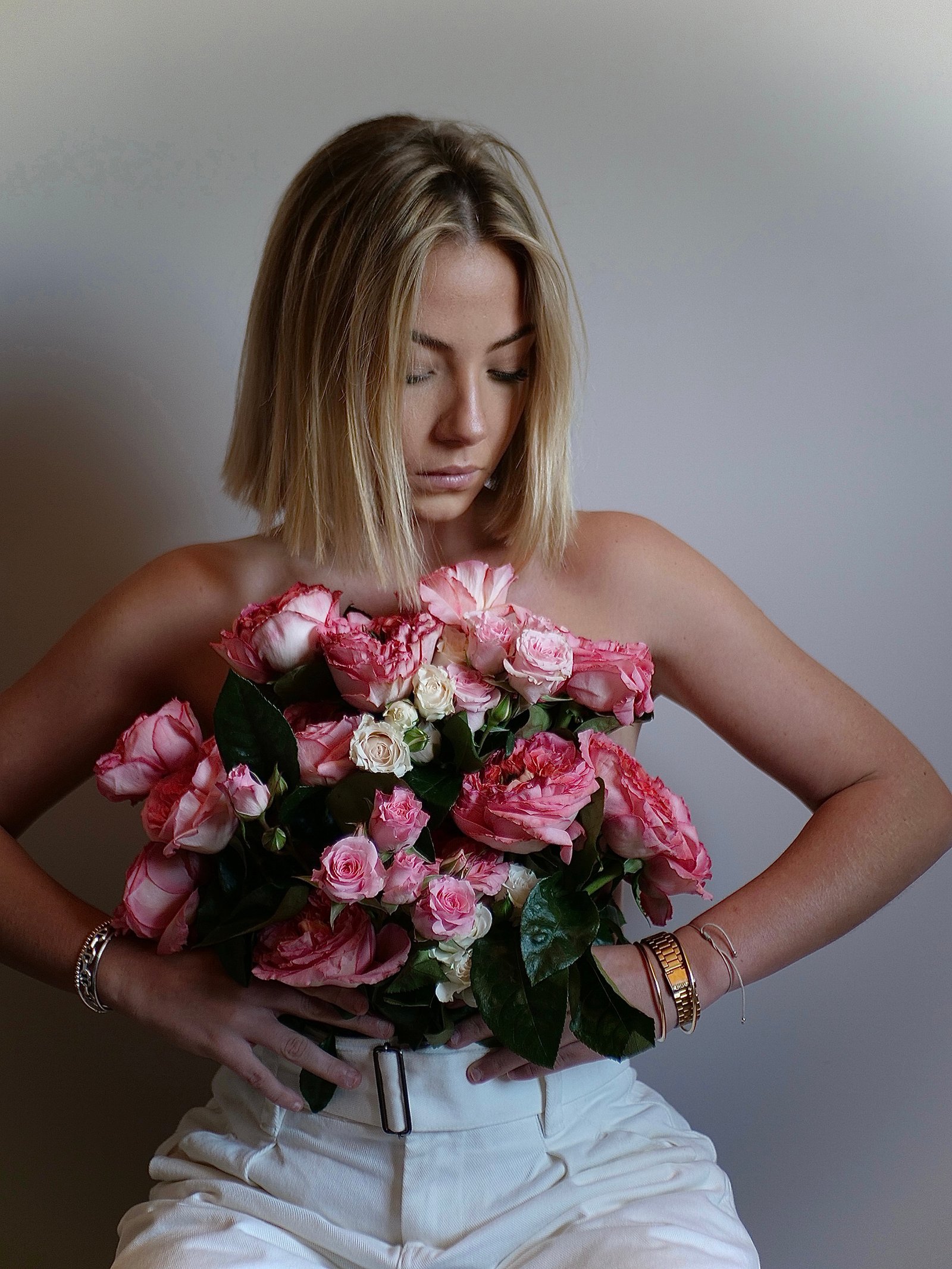 une jeune femme avec un bouquet qui cache sa poitrine.