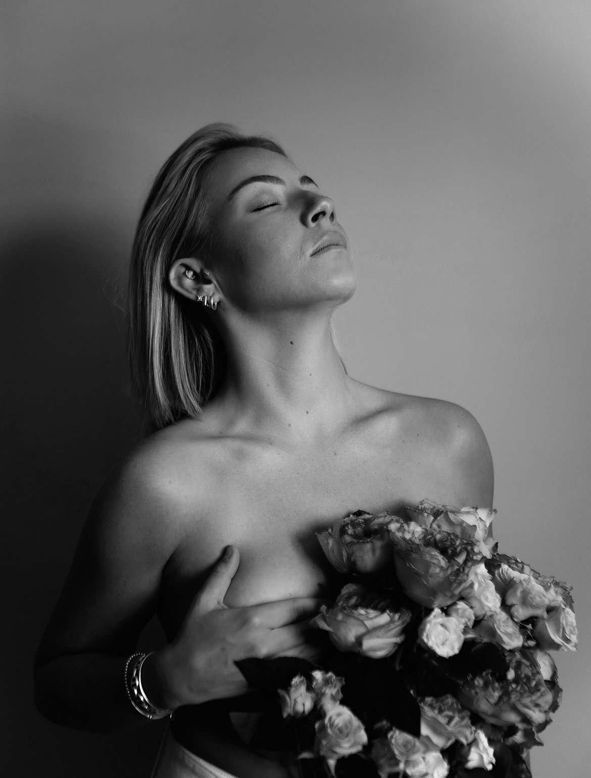 une jeune fille avec sa main sur sa poitrine avec un bouquet les yeux fermé