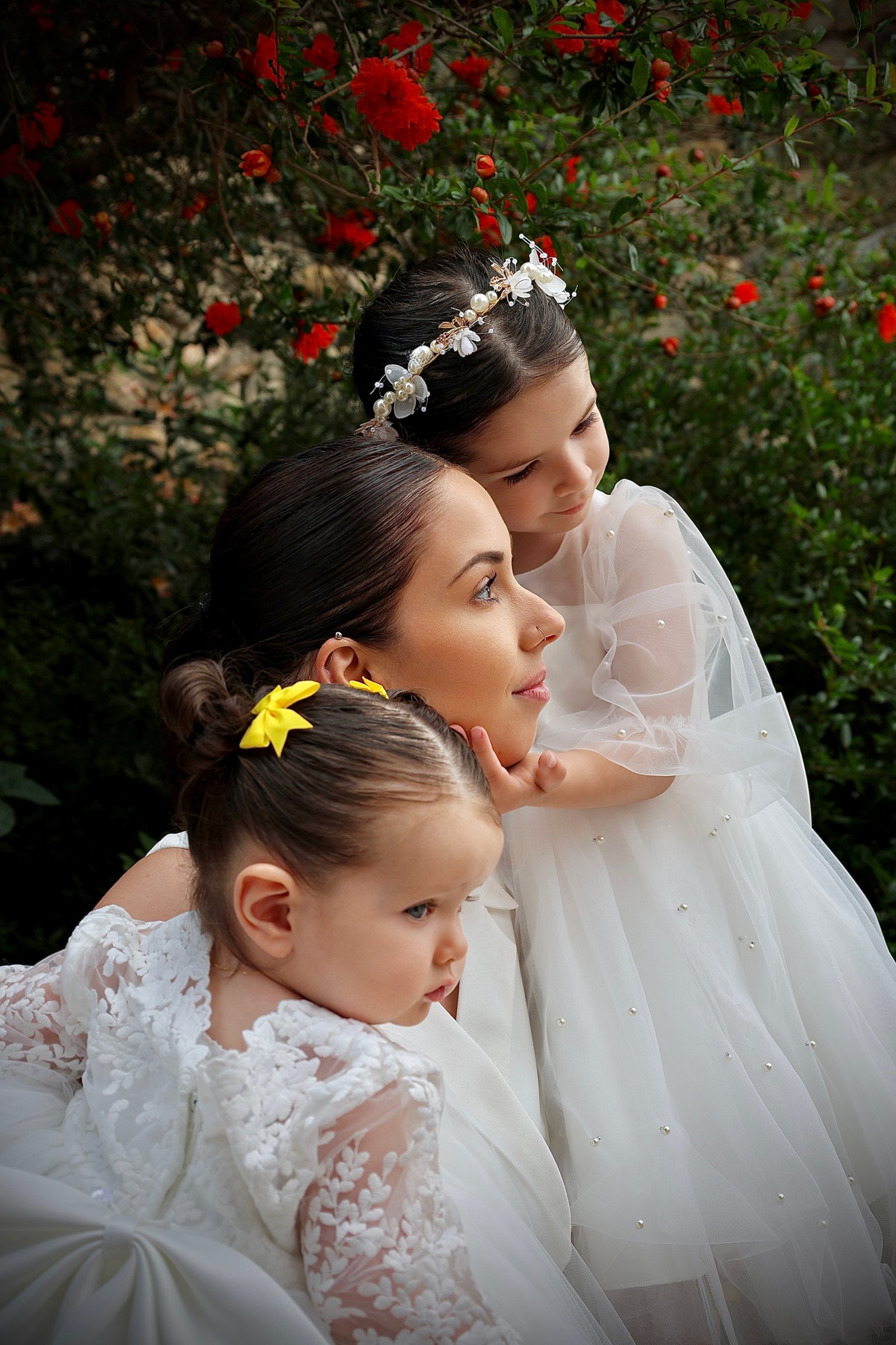 une maman avec ses deux filles le jour de leur baptêmes 