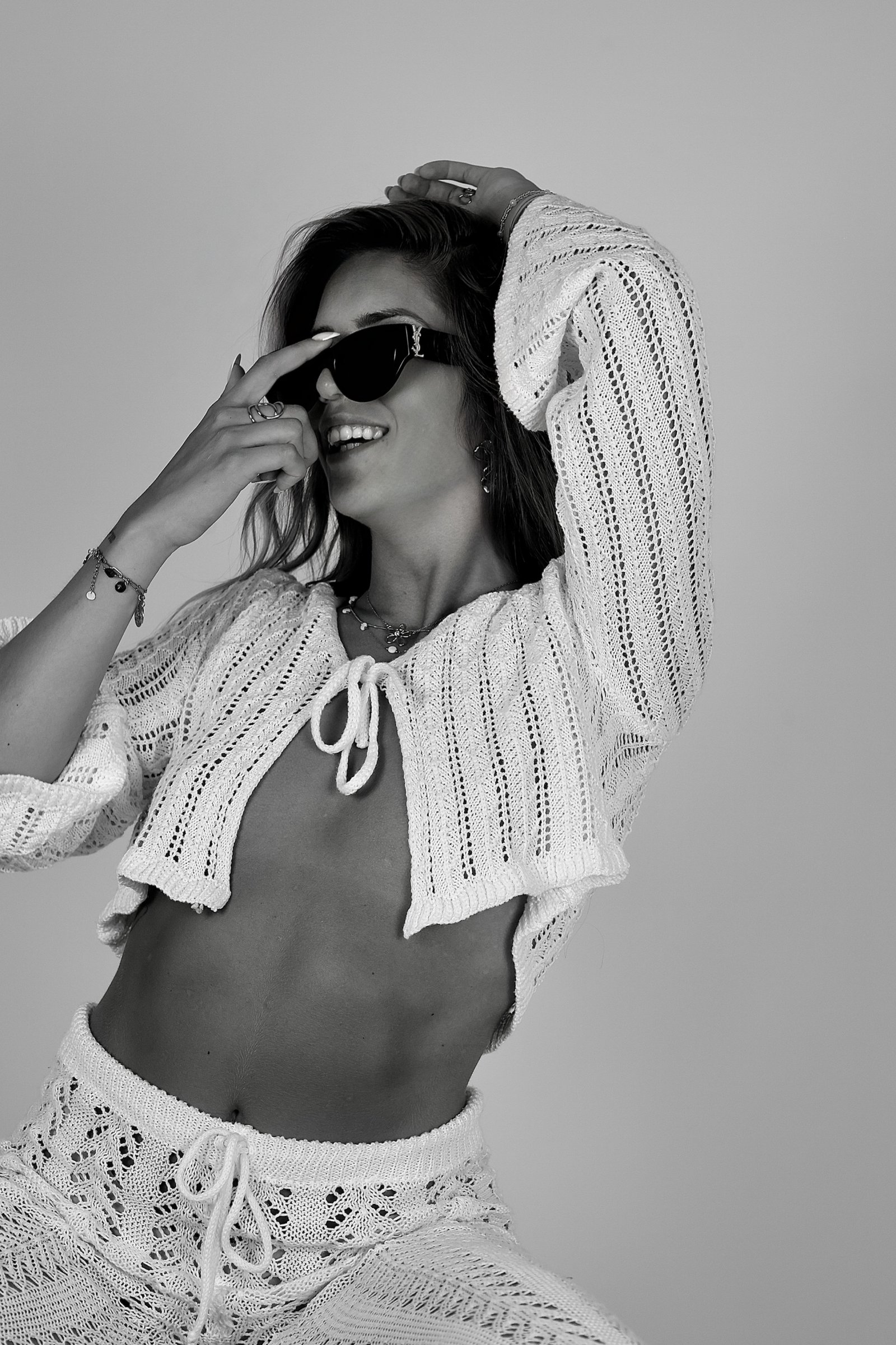 jeune femme avec ses lunettes de soleil et un grand sourire 