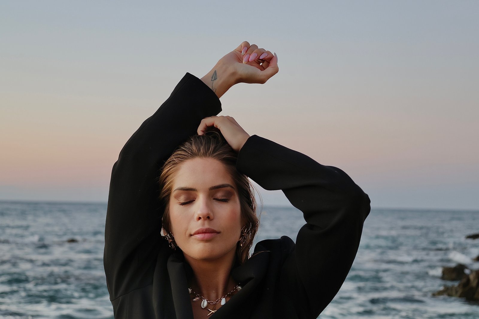 jeune femme face a la mer avec les yeux fermé
