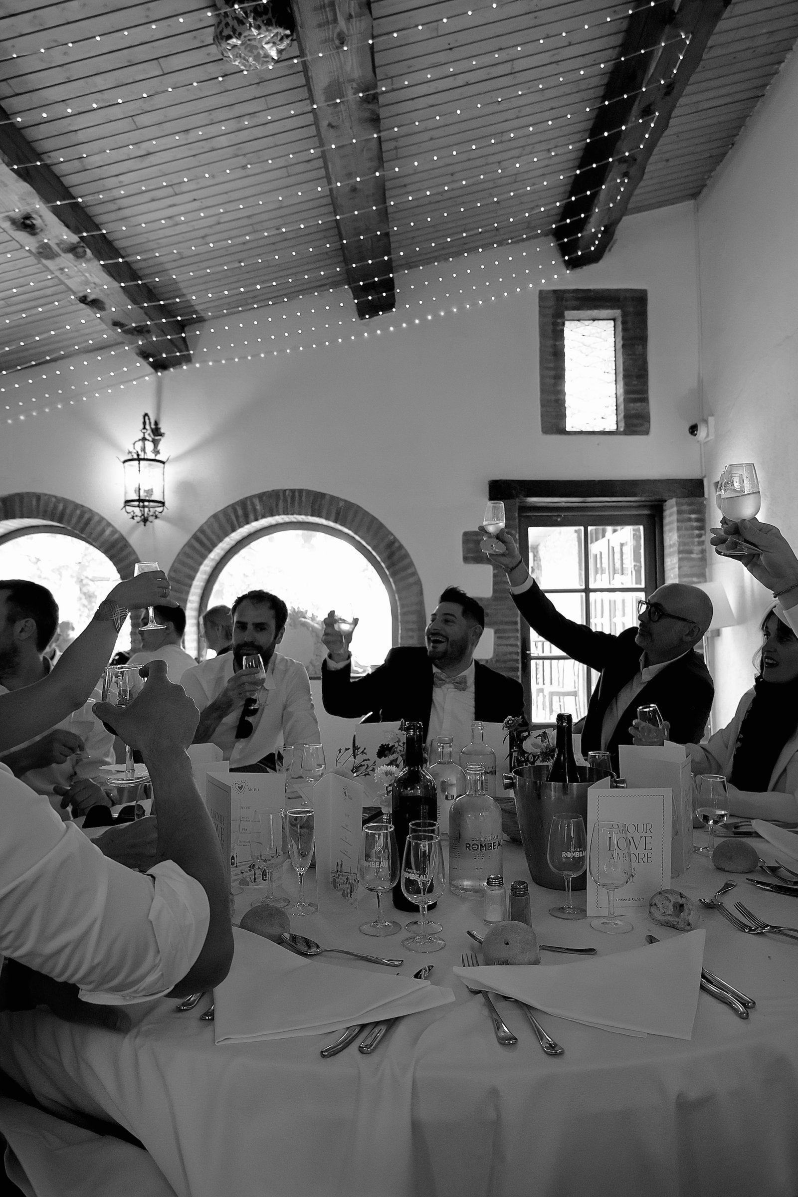 une groupe d'ami invités à un mariage levant leurs verres au mariés