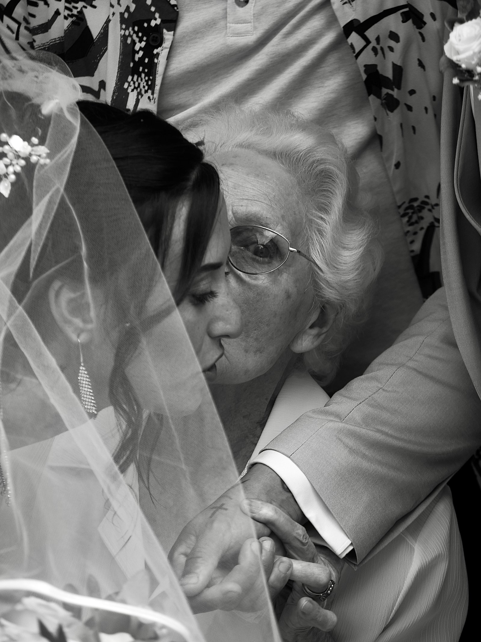 une dame âgée embrassant sa petite fille le jour de son mariage