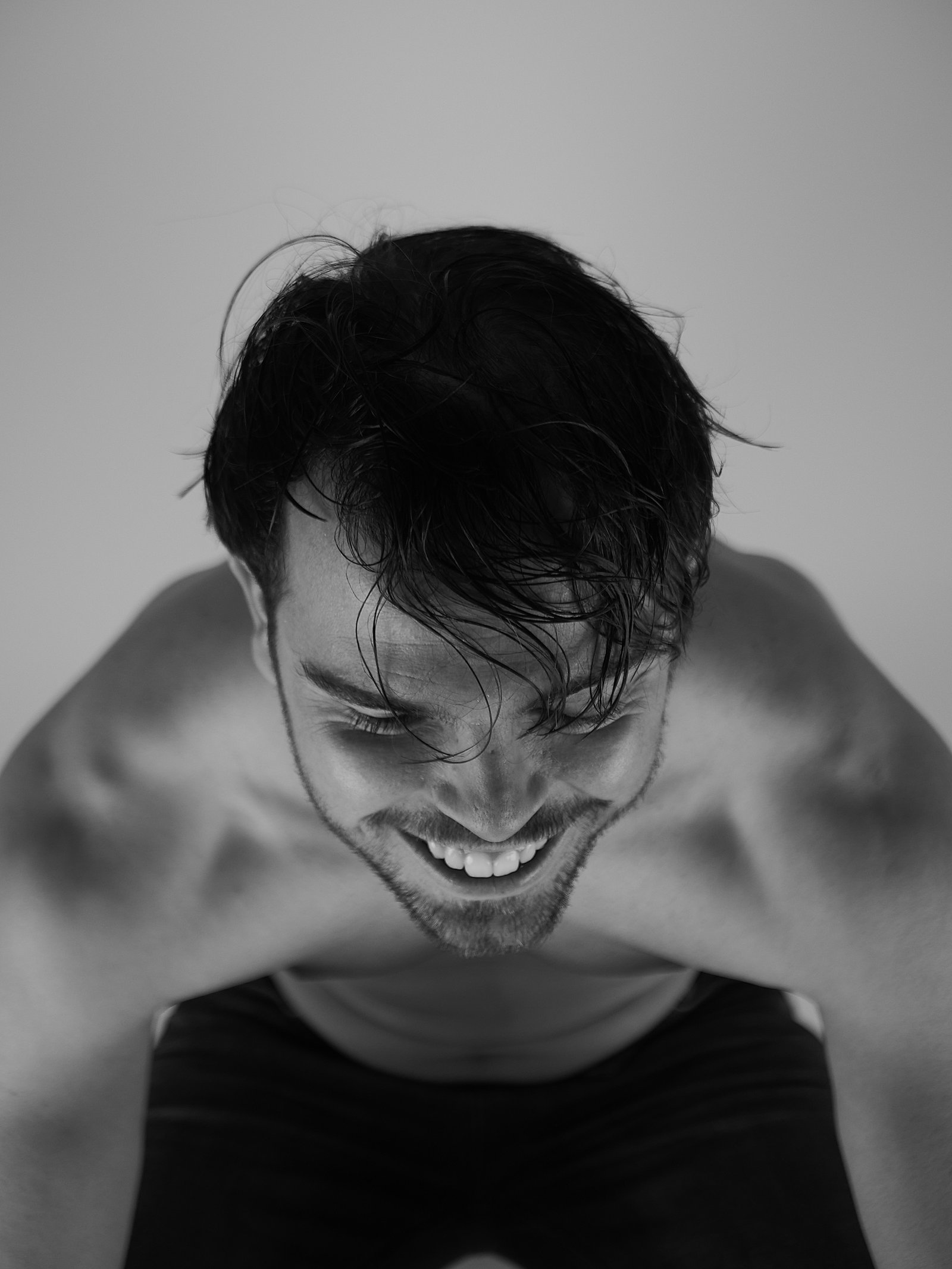 un jeune homme assis qui souris 