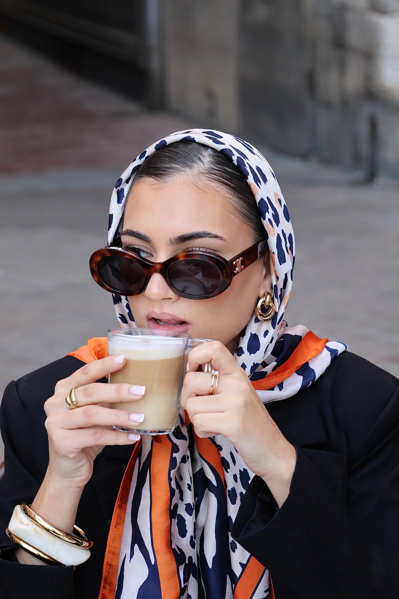 jeune femme en train de boire son cafe avec un foulard sur la tête 