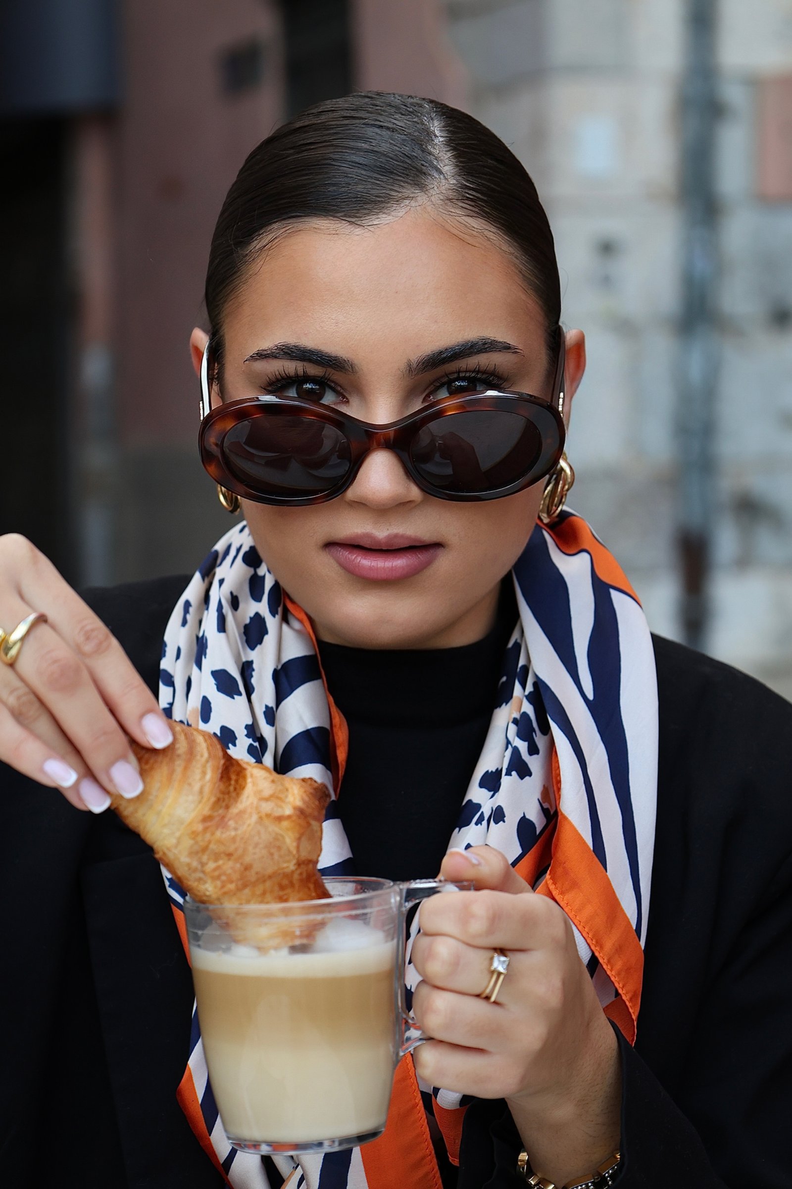 Jeune femme qui trempe son croissant de son cafe et qui me regarde 